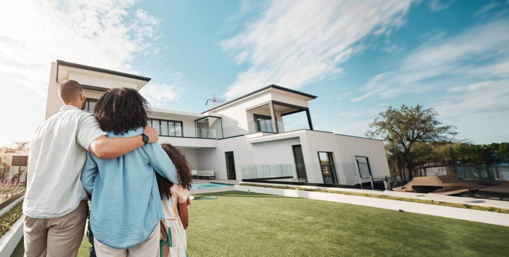 Family standing on their lawn admiring their home